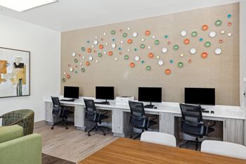an office with computers and chairs and a wall with colorful spheres on it